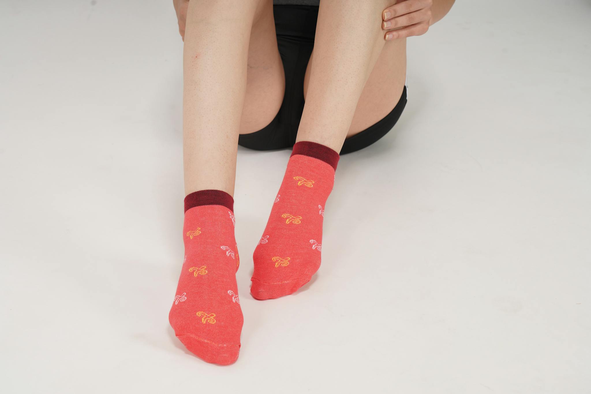 A close-up shot of a woman's legs wearing red socks with a pattern, featuring copy space.