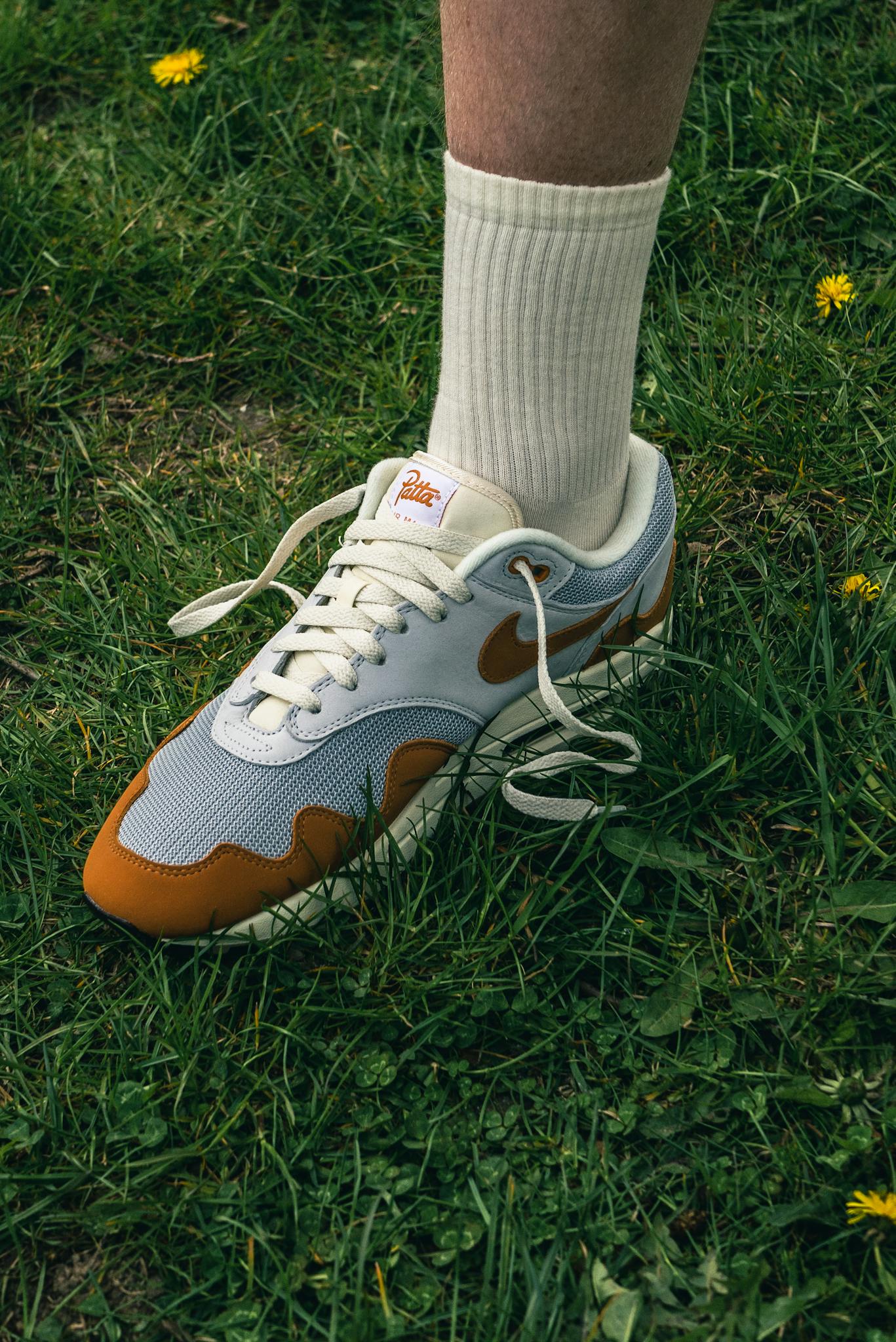 Close-up of trendy Nike sneakers on green grass, showcasing fashion footwear.