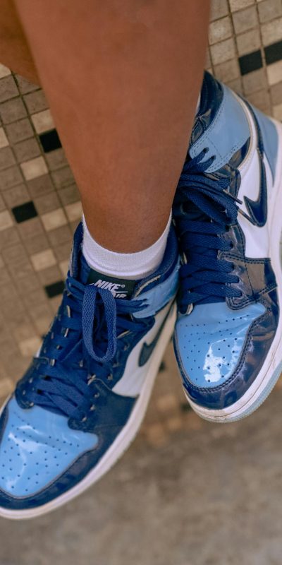 Stylish blue Nike sneakers worn by a person, showcasing footwear fashion.