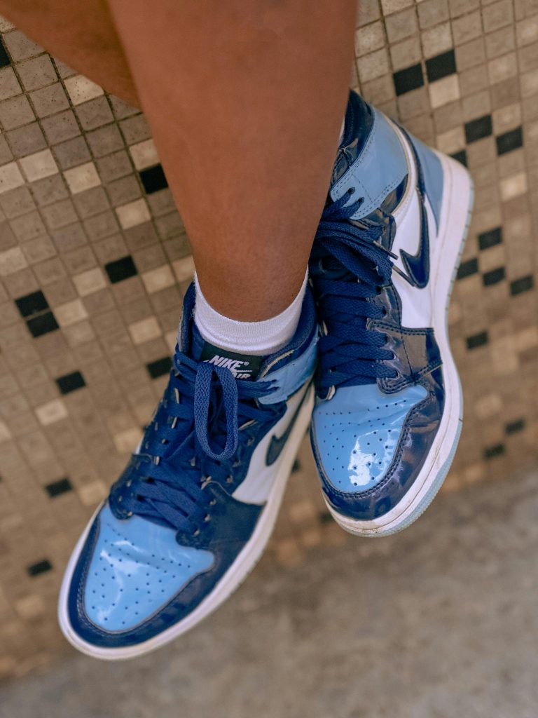 Stylish blue Nike sneakers worn by a person, showcasing footwear fashion.
